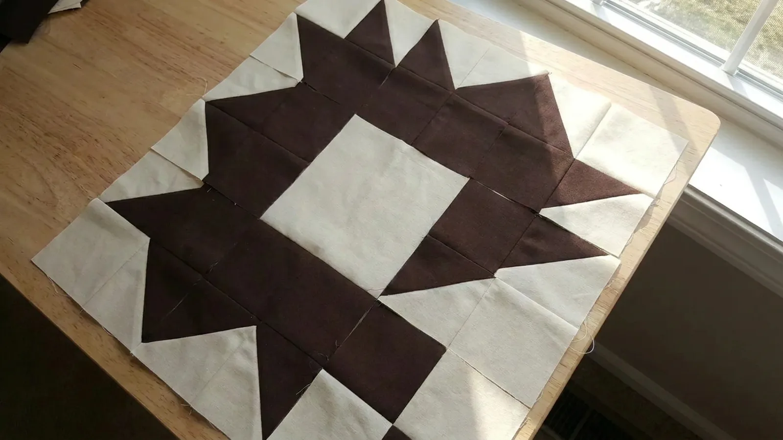 Illustrative generated image of brown and cream triangle units arranged on a light wood table.