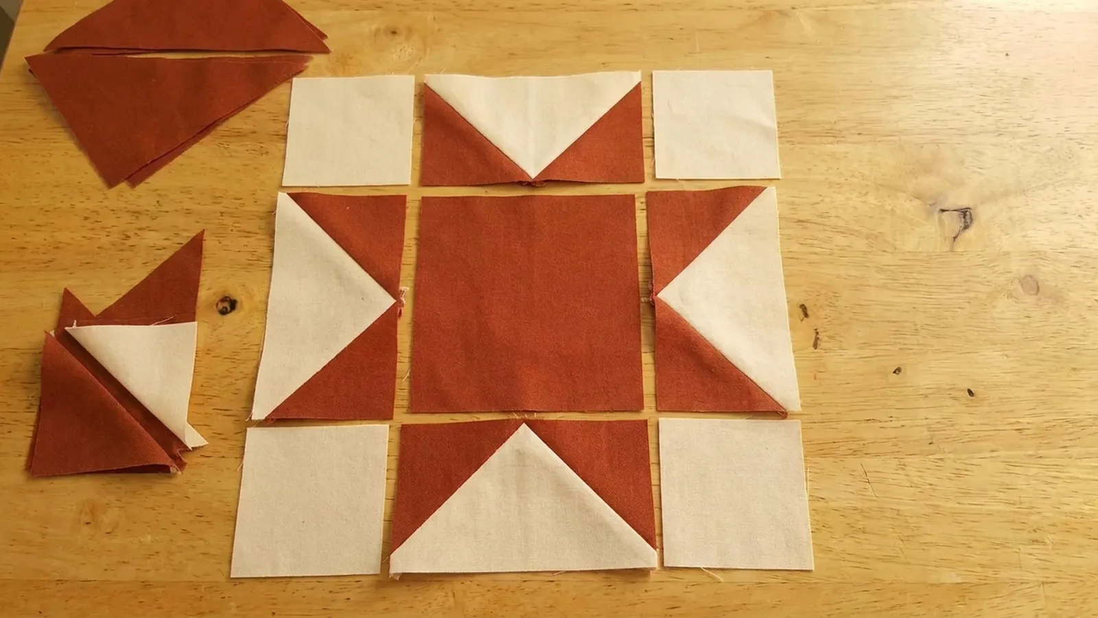 Illustrative generated image of rust and cream star-point units laid out on a wooden table.